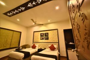 a hotel room with two beds and a ceiling at Casa Broadway-A Boutique Hotel in Kolkata