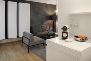 a kitchen and living room with a chair and a table at AMANO HOME Apartments in Berlin