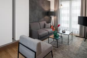 a living room with a couch and a table at AMANO HOME Apartments in Berlin