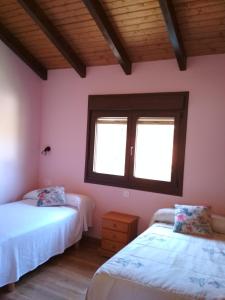 1 dormitorio con 2 camas y ventana en Apartamentos Rurales Casa Fonso, en Navia