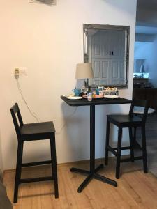 a table with two chairs and a mirror on a wall at Galéria Panzió in Nagykanizsa