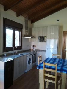 cocina con fregadero y mesa con mantel azul en Apartamentos Rurales Casa Fonso, en Navia