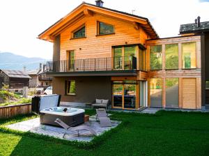a house with a hot tub in the yard at Hotel Piccolo Tibet in Livigno