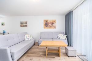 a living room with a couch and a coffee table at Seaside Breeze Stylish Apartment Balcony & Parking by Renters in Międzyzdroje