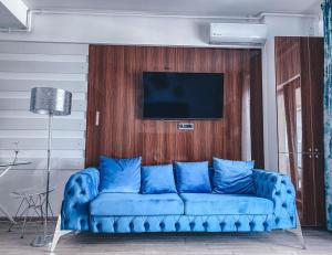 a blue couch in a living room with a tv at Mamaia Luxury Studio Apartment V in Mamaia