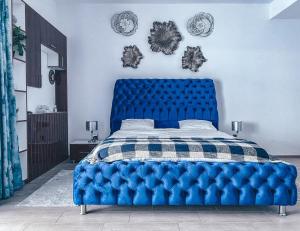 a blue tufted bed in a blue bedroom at Mamaia Luxury Studio Apartment V in Mamaia +16 photos