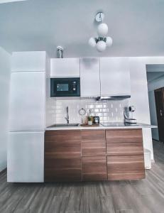 a kitchen with white appliances and wooden cabinets at Mamaia Luxury Studio Apartment V in Mamaia