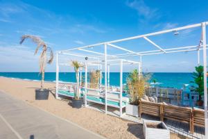 a pavilion on the beach with benches and the ocean at HomeHolidaysRentals Amaral in Pineda de Mar