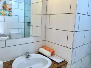 a white bathroom with a sink and a mirror at Apartamento La Piedra DIRECTO en Playa in La Oliva