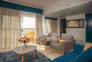 a living room with a couch and chairs and a table at Mercure Ismailia Forsan Island in Ismailia