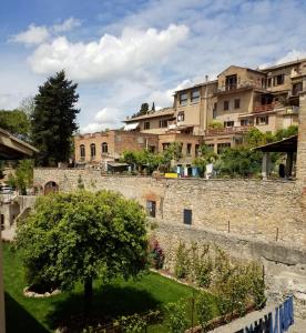 Blick auf eine Stadt mit einer Mauer und einem Baum in der Unterkunft Contemporary Rooms in San Gimignano