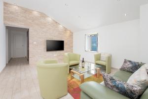 ein Wohnzimmer mit Sofa, Sesseln und Fernseher in der Unterkunft Apartments D&V in Kotor
