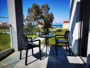 stół i krzesła na balkonie z widokiem na ocean w obiekcie Anemona Beach apartments w Sidari