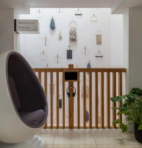 a room with a chair and a clock on the wall at Inhabit, Southwick Street in London