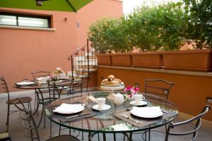 two tables and chairs on a patio with flowers at Artemis Hotel in Cefalù