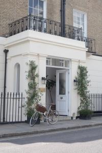 ein Fahrrad, das vor einem weißen Haus geparkt ist in der Unterkunft Inhabit Southwick Street, a Member of Design Hotels in London