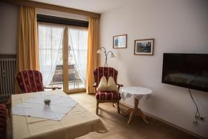 a living room with a table and chairs and a television at Haus Feichtner in Reit im Winkl