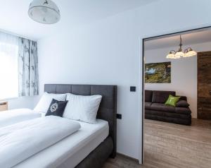 sypialnia z białym łóżkiem i lustrem w obiekcie Apartment Tauernfex Kaprun w Kaprunie