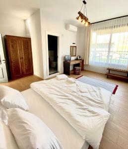a large white bed in a room with a window at Moya Urla Butik Otel in Izmir