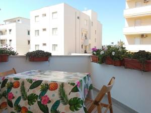 uma mesa e cadeiras numa varanda com vasos de plantas em House Lido em Gallipoli