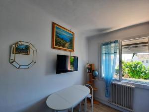 een witte kamer met een tafel en een raam bij CHAMBRES Climatisées Confort,WIFI, GARE TGV,parking,pt dejeuner in Perpignan