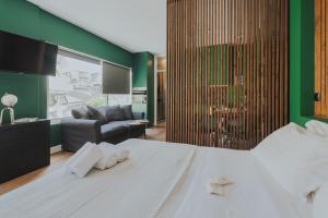a bedroom with a white bed and a green wall at K-Houses B2 in Arta