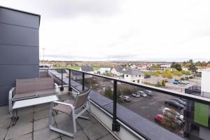 a balcony with a table and chairs and a parking lot at Aparthotel Adagio Bâle Mulhouse Aeroport in Blotzheim
