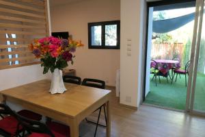 Una habitación con una mesa con un jarrón de flores. en Villa Carémeau 1, en Nimes