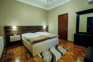 a bedroom with a large bed and a wooden headboard at Hotel Eurica in Kutaisi