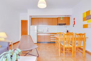 cocina y comedor con mesa y sillas en AL - Apartamento Infante Sagres, en Quarteira