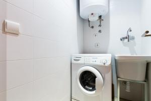 a laundry room with a washing machine and a sink at the beach milenium in Roses