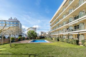 a swimming pool in a yard next to a building at the beach milenium in Roses