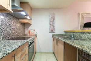 - une cuisine avec des comptoirs en granit et un évier dans l'établissement the beach milenium, à Roses