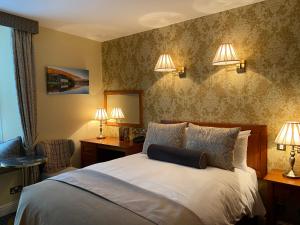 1 dormitorio con 1 cama con 2 luces en la pared en Blarney Castle Hotel en Blarney