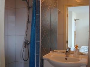 a bathroom with a sink and a shower with a mirror at Hotel Rasch in Bergen aan Zee