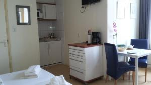 une cuisine avec un bureau, une table et une chaise bleue dans l'établissement Hotel Rasch, à Bergen aan Zee