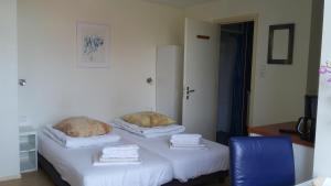 Zimmer mit einem Bett mit zwei Kissen darauf in der Unterkunft Hotel Rasch in Bergen aan Zee