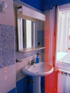 La salle de bains est pourvue d'un lavabo blanc et d'un miroir. dans l'établissement La Casa del Giglio, à Albenga