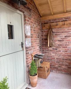 a brick wall with a white door and a crate at The Stable, Yew Tree Farm Holidays, Tattenhall, Chester in Chester