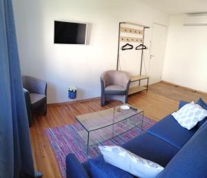 a living room with a blue couch and two chairs at Le domaine de Moïse in La Fouillade