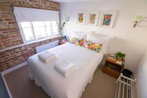 a bedroom with a white bed with pillows and a window at Dog and Whistle Pub in Hertford