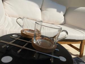 dos vasos de beber en una mesa junto a un sofá en La Fleur Marine Classé 3 étoiles - Accès direct mer Cabourg, en Cabourg 9 fotos más