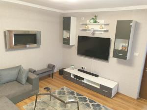 a living room with a couch and a flat screen tv at Kogalniceanu House in Constanţa