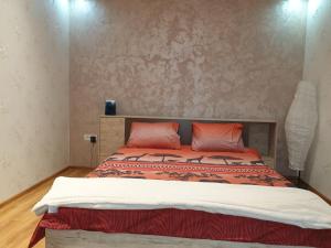 a bedroom with a bed with two orange pillows at Kogalniceanu House in Constanţa