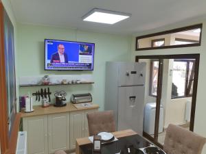 a kitchen with a refrigerator and a tv on the wall at Kogalniceanu House in Constanţa +18 photos