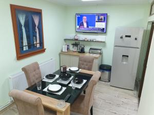 a kitchen with a table and chairs and a refrigerator at Kogalniceanu House in Constanţa