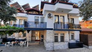 a house with balconies and a table and chairs at Mut Apart Hotel in Fethiye