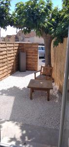 塞里尼昂的住宿－Plénitude，木凳坐在围栏旁边的树下