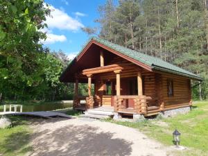 a log cabin in the woods with a porch at Pušų Šlamesy in Vilnius