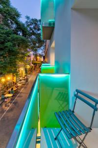 a blue bench on a balcony with a street at Ivis 4 Boutique Hotel in Athens